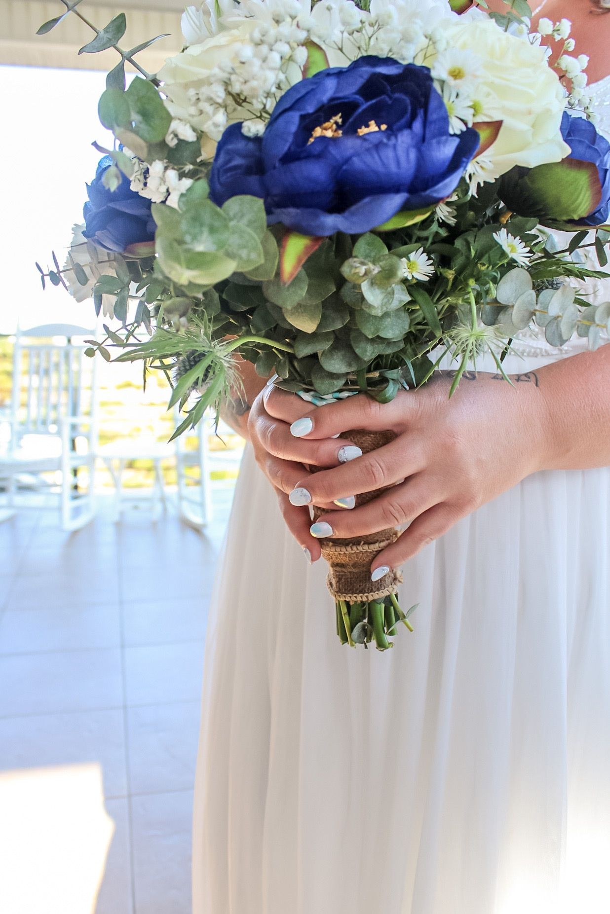 Bride holding a blue and white wedding bouquet, photographed by Miranda Rae