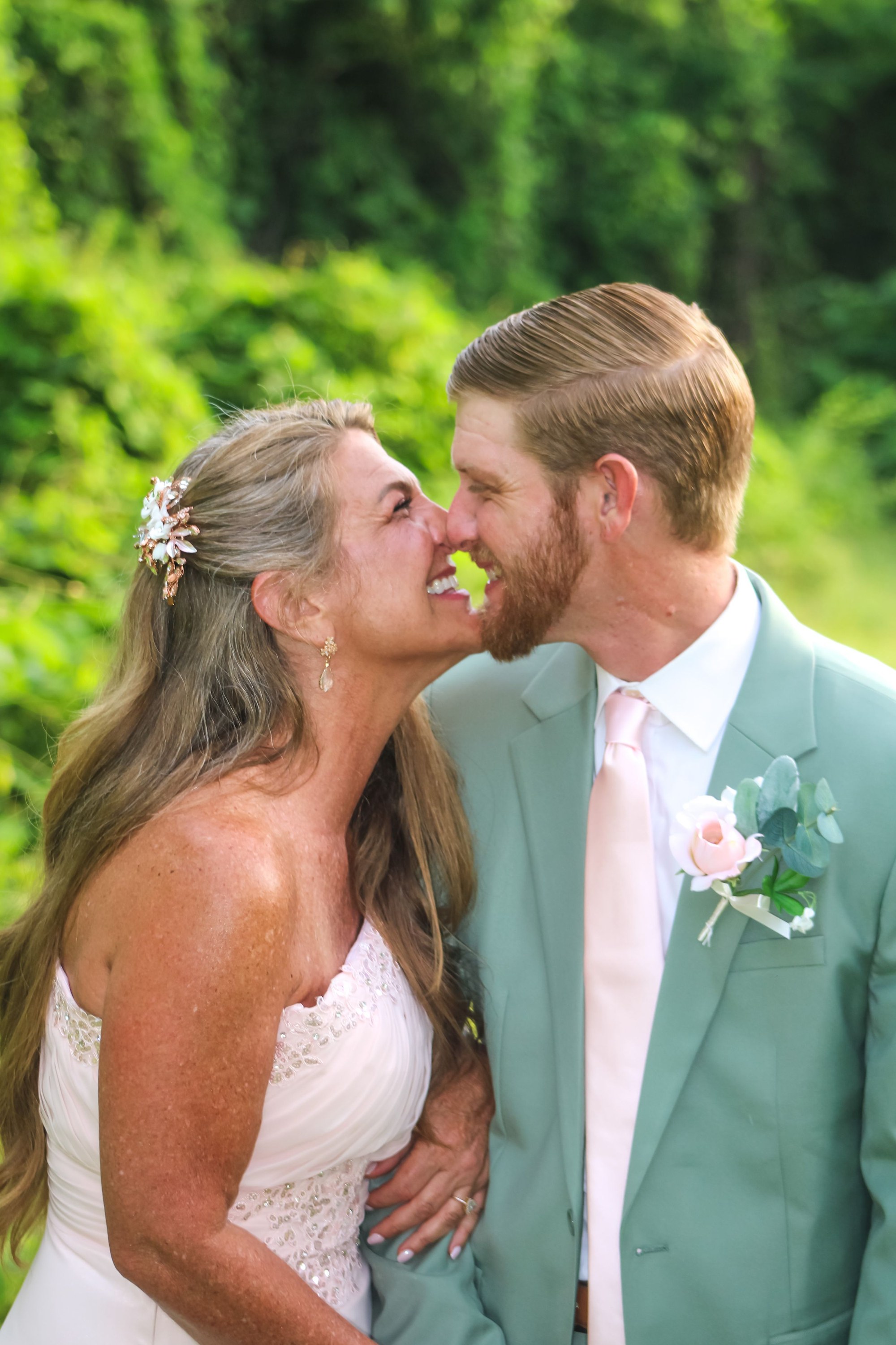 Bride and groom laughing nose to nose on their wedding day, photographed by Miranda Rae